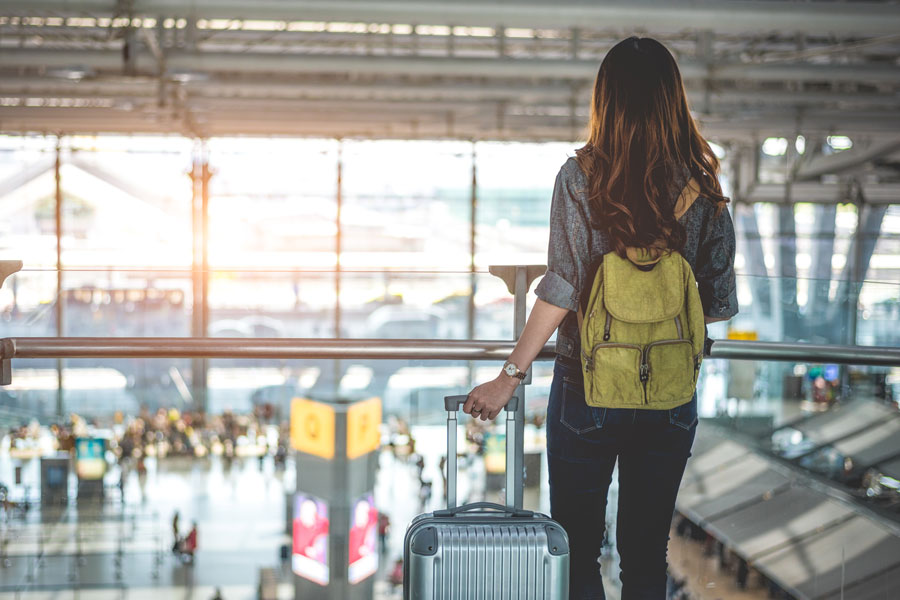 Student in airport with suitcase