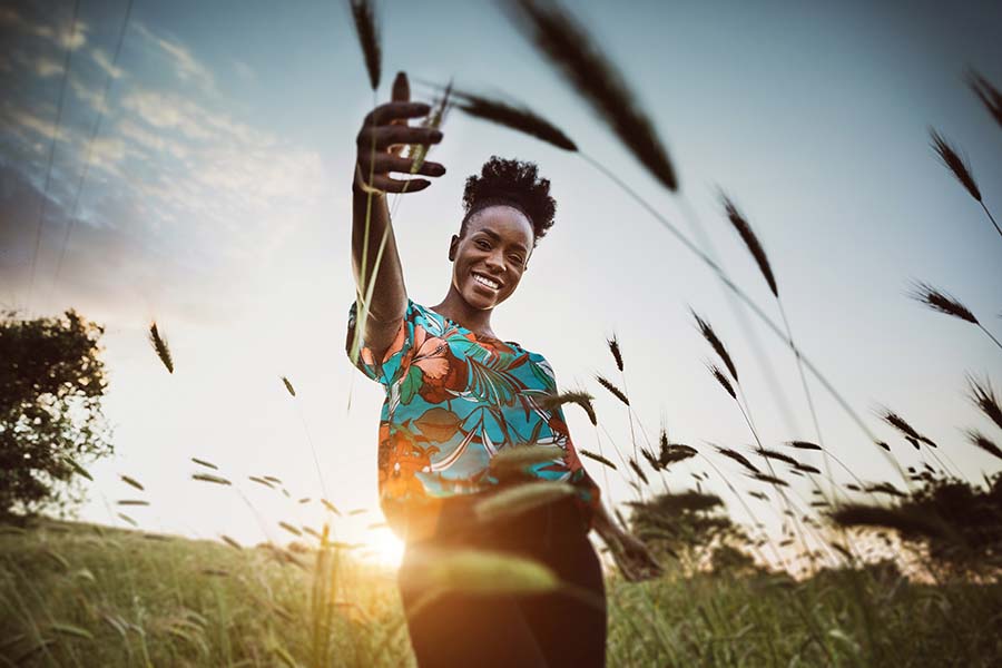 woman outside at sunset in prairie grass