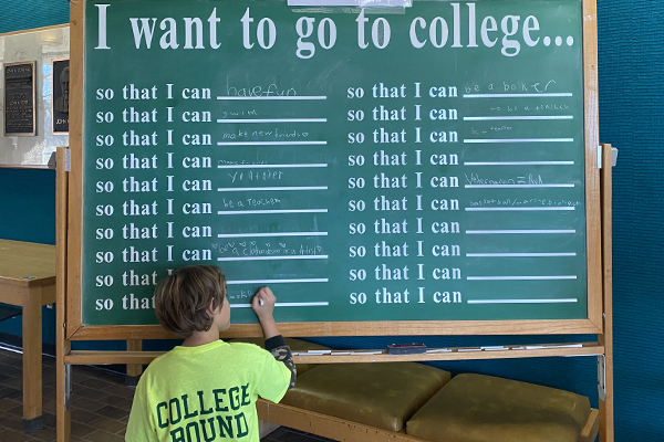 Student writing on chalkboard