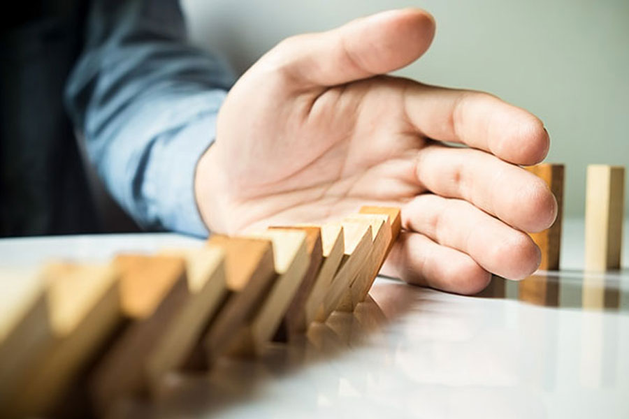 hand catching falling dominos