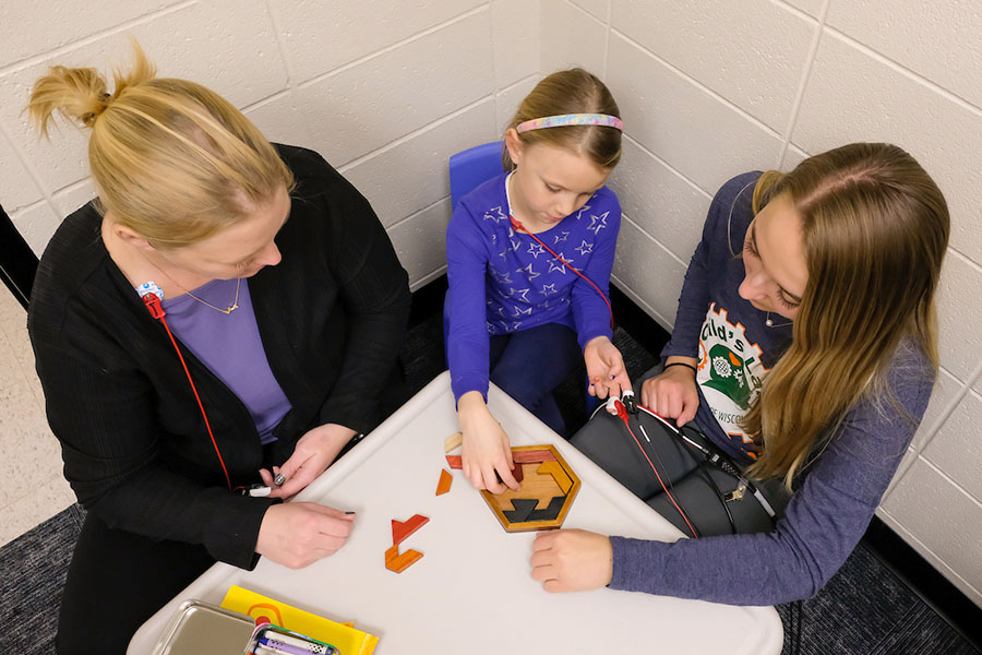 Researchers playing a game with young girl