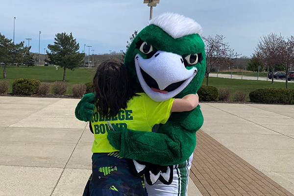 Phlash Mascot hugging student