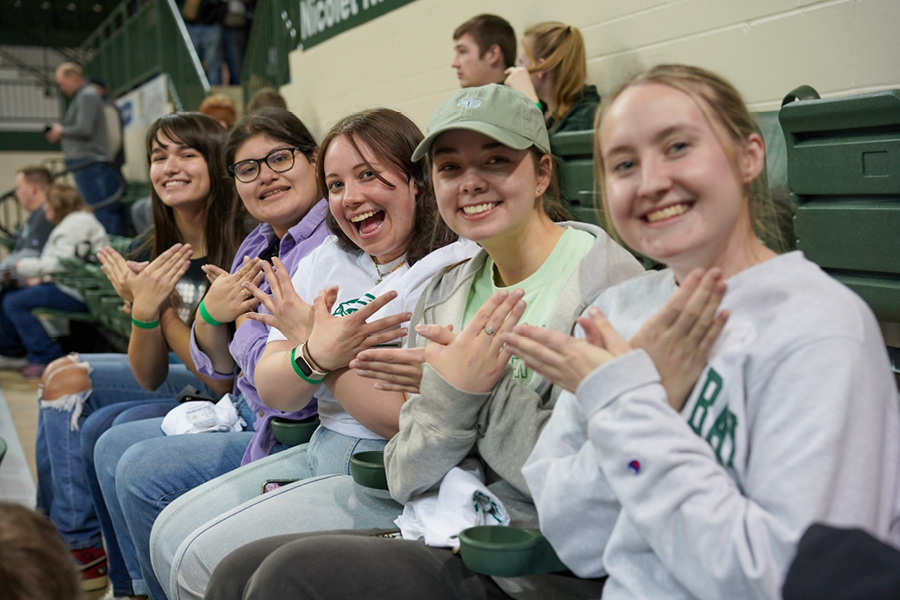 Five students hold their hands up in the Phoenix gesture