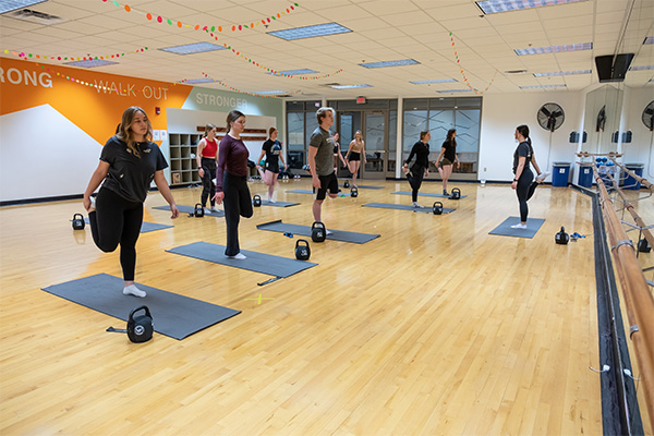 Group exercise class with mats and kettelbell weights in the uwgb aerobics studio