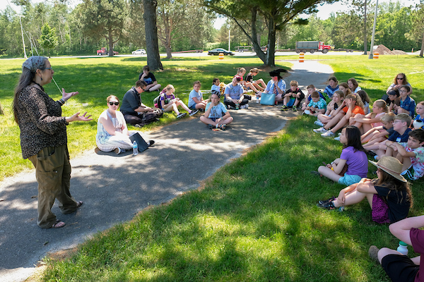 Camp counselor talking to campers outside