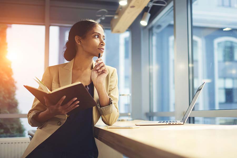 Business woman looking thoughtfully and confidently out a window