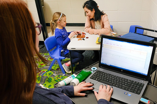 Researcher playing a game with young girl