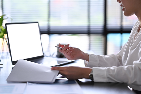 Woman in front of computer with paperwork