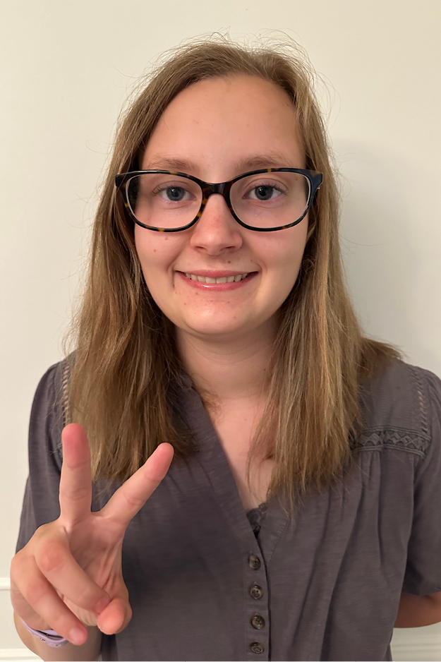 A female student holding up a peace sign