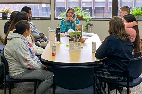 Students listening and talking to a Tribal Eldert table