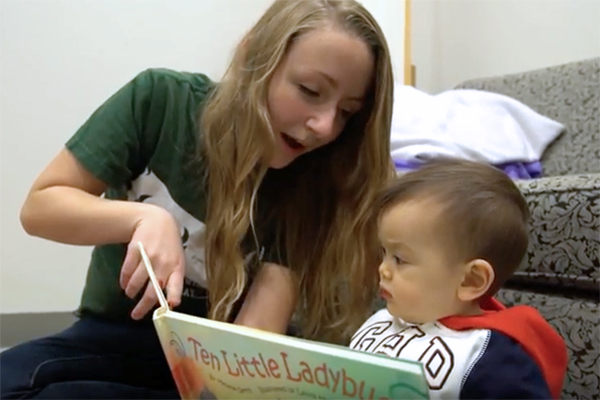 Young woman reading to a small child