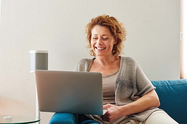 woman looking at laptop screen sitting on a couch