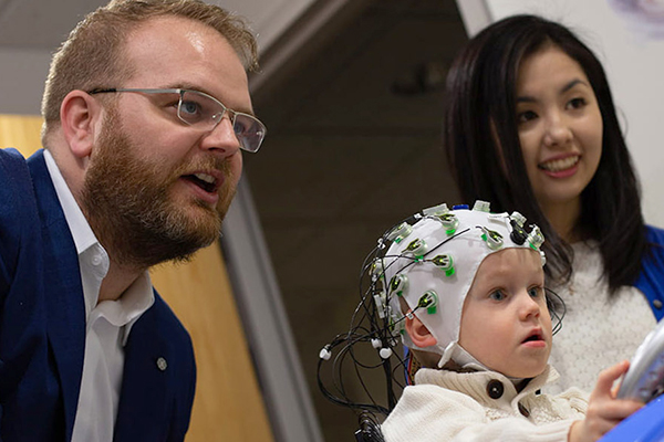 Researchers with small child in EEG cap