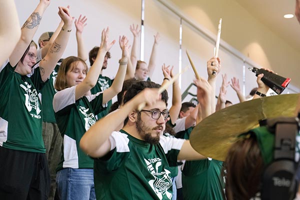 Excited drummer with pep band students at game