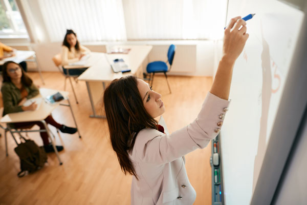 Teacher writing on whiteboard