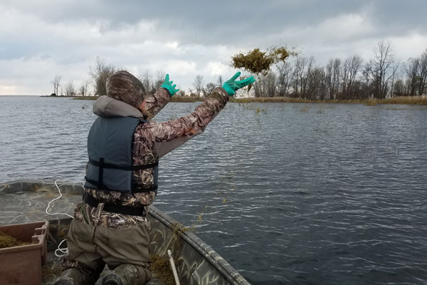 Student on boat throwing seeds into water