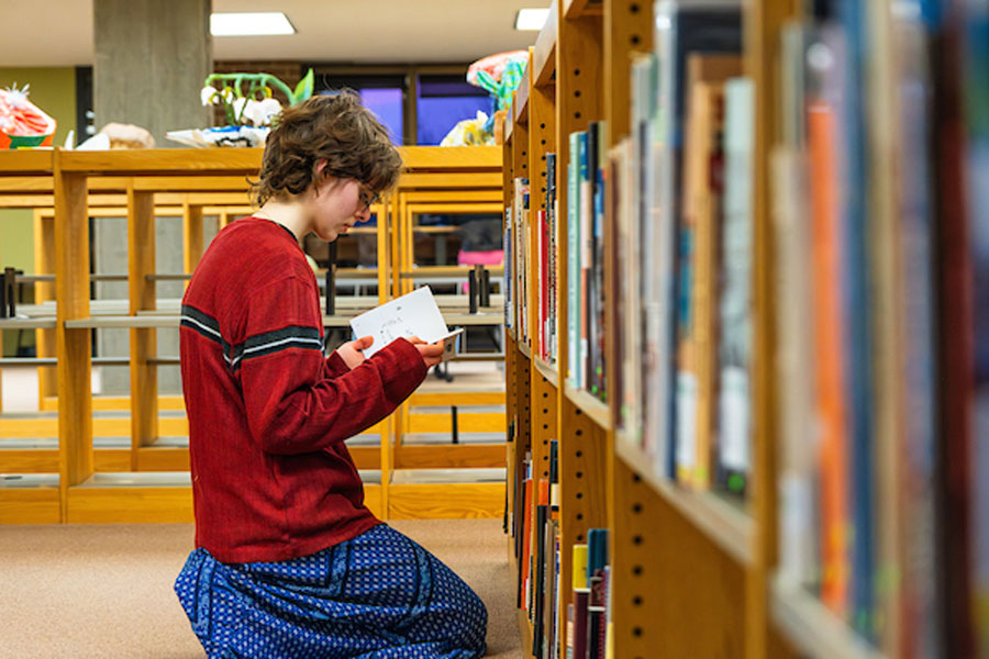 Student looking through First Nations book collection