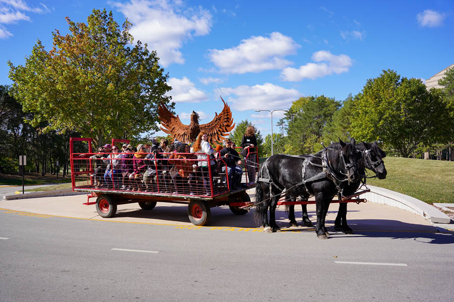 Families enjoy a horse-drawn wagon ride