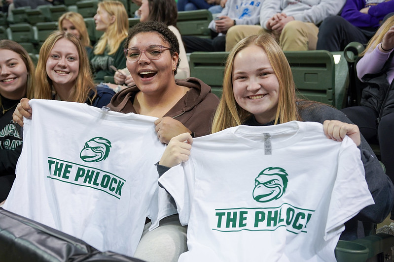 Students hold up t-shirts that read "The Phlock"