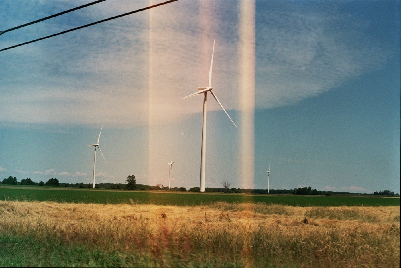 Photo: Windmills with light framing the one in the center.