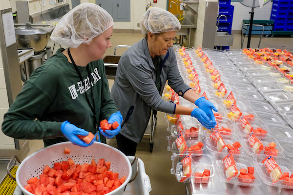 Graduate student works in kitchen at summer practicum