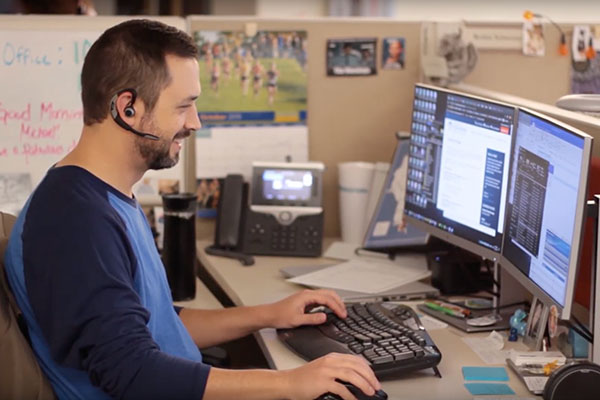 Academic support employee at desk with headset