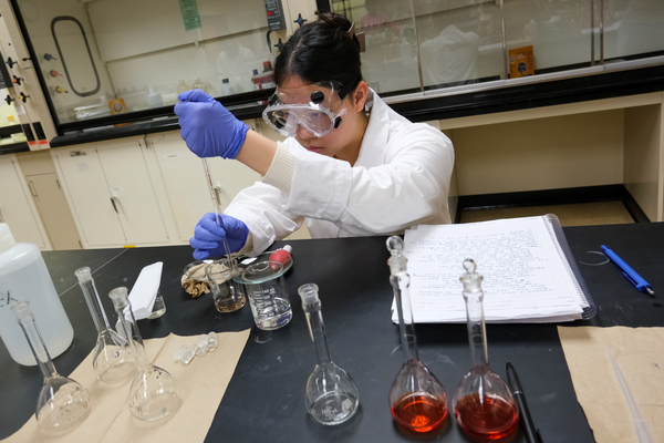 Chem student testing fluids in beakers