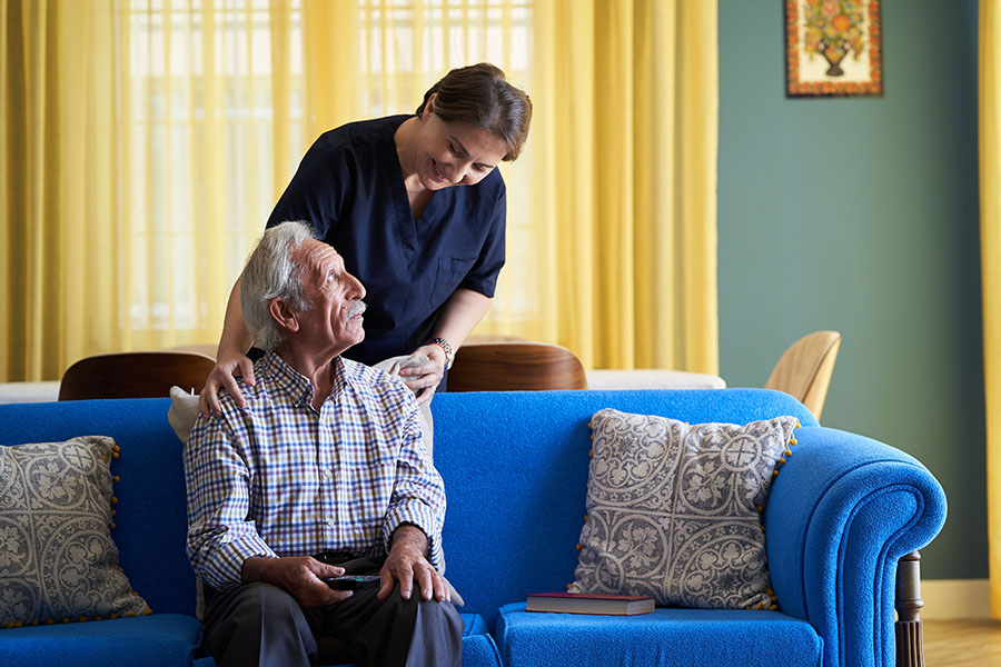 caregiver helping senior man with television