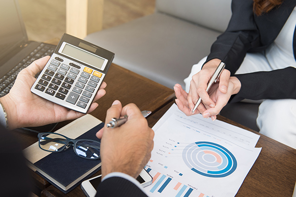 Person holding calculator and reviewing charts