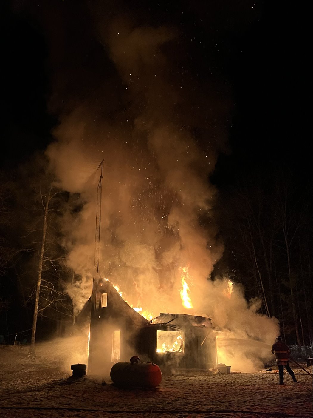 Photo: A home burning at night.