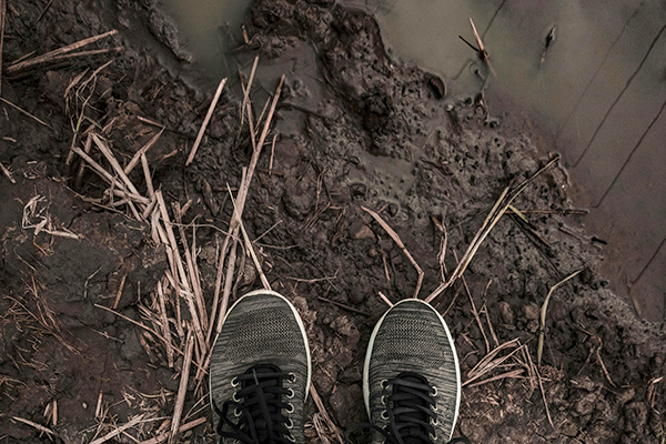 Feet in wet muddy ground