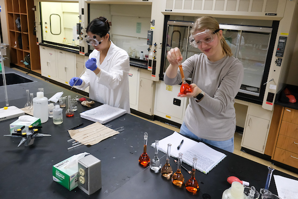 Two students expirementing in analytical chemistry lab