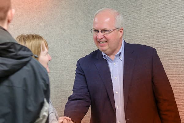 Craig Dickman greets student veterans at a naming event