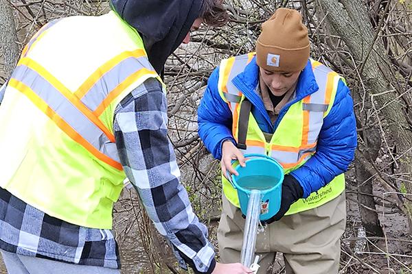 Two researchers taking water samples