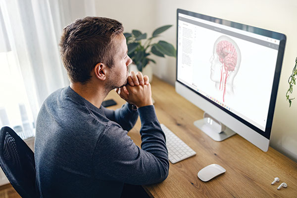 man looking at 2D model on computer screen