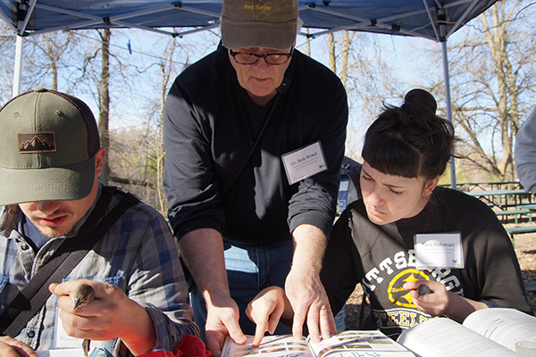 an instructor and a student pointing at a diagram in a book