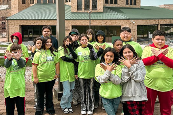 Group of kids making wings symbol with their hands