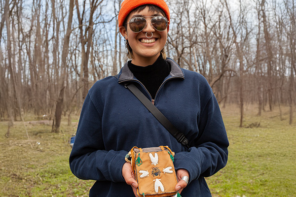 Smiling Indigenous woman showing handmade pouch