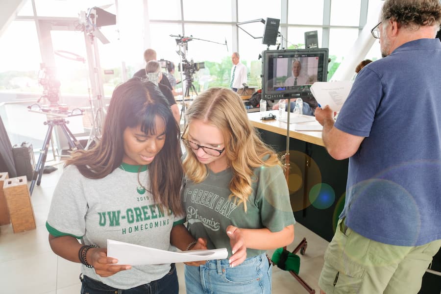 Students reading script for commercial being filmed