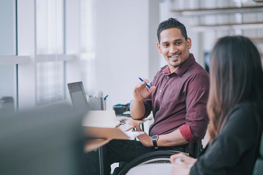 man in a wheelchair talking with coworker equity certificate concept