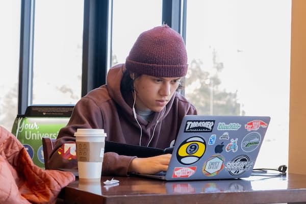 Student in coffee shop with laptop