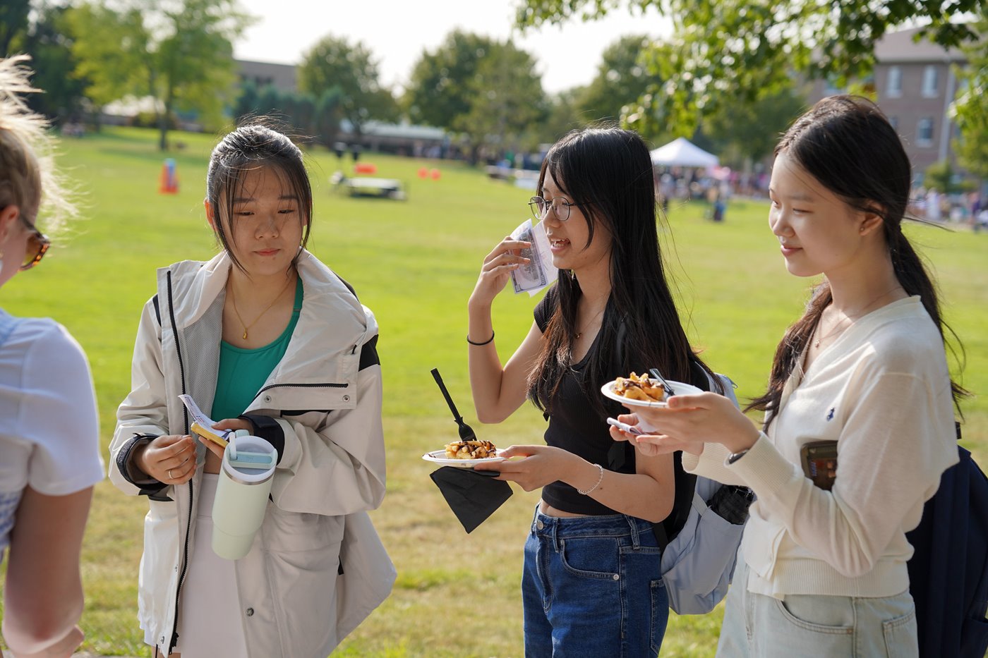 Students socialize and eat food at an outdoor event