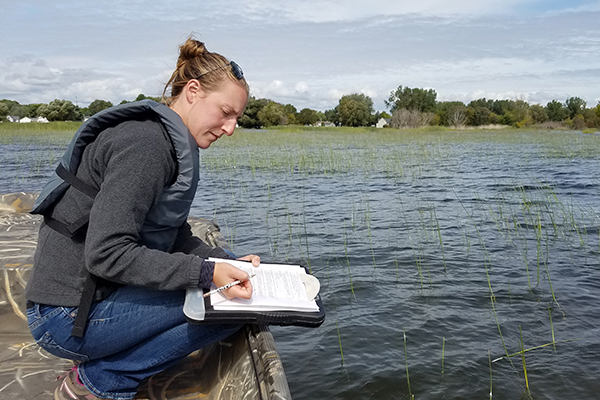 Female researcher taking notes in a boat