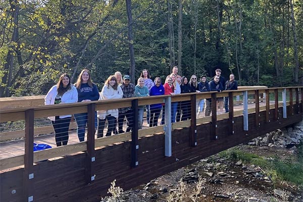 students pose on bridge