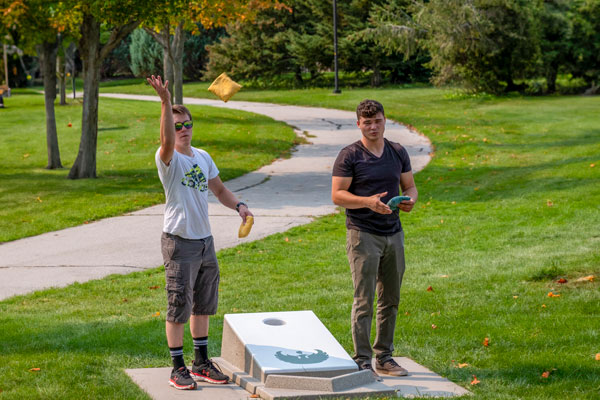 Students playing bags outside