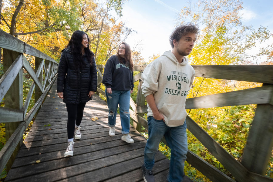 Students walking on Cofrin Arboretumbridge 