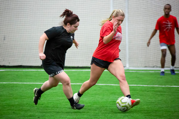 Two female students playing soccer