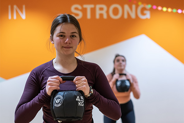 students using kettelbells in uwgb strength group exercise class